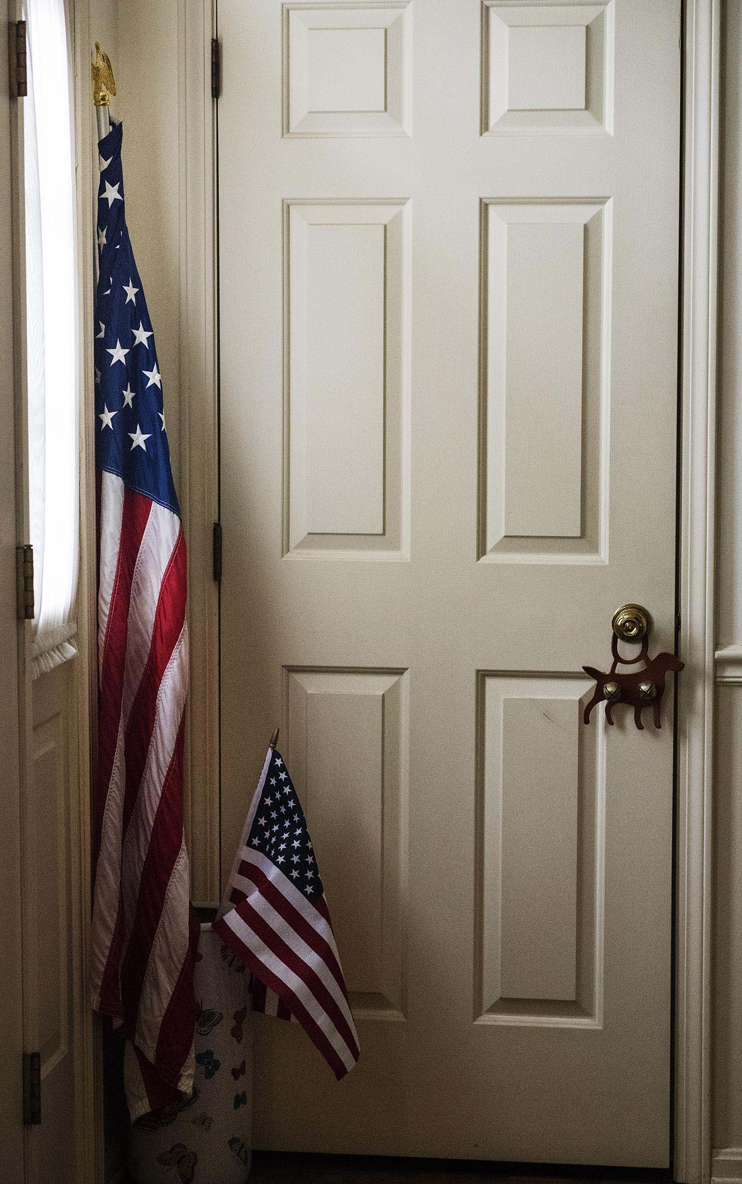  American flags sit next to the front door of Adam Nilson's mom's house.